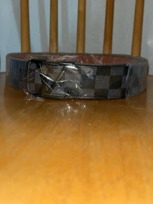 L-v Bälte Svart Rutig - Säljer ett helt nytt riktigt snyggt svart L-v bälte med svart logga.