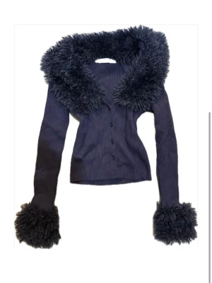 Svart kofta med fuskpäls från Bershka - Marinblå  ribbad kofta från Bershka med stora fluffiga fuskpälsdetaljer vid krage och ärmslut. I mycket bra skick🥰