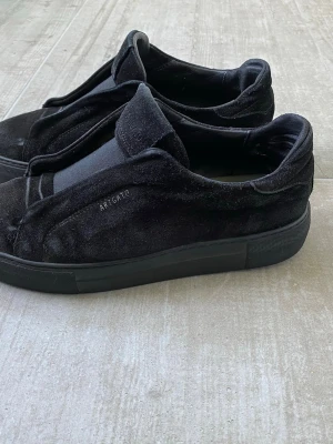 Axel arigato laceless - Snygga svarta skor, lite skadade i hälen på insidan av skon