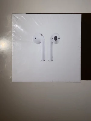 Airpods 2nd Gen - Säljer ett par Apple AirPods med trådlöst laddningsetui. Komplett i originalförpackning med laddkabel och manual. Perfekt för trådlös musik och samtal med hög kvalitet.