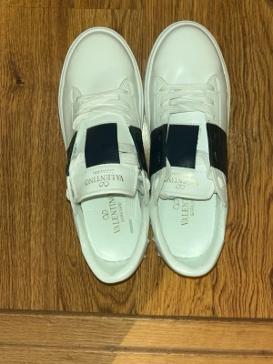 Valentino Garavani Open sneakers vit/blå - Säljer ett par snygga Valentino Garavani Open sneakers då de är för små för mig. Skorna är bara testade och kommer helt nya med box och påse. Priset är inte hugget i sten!