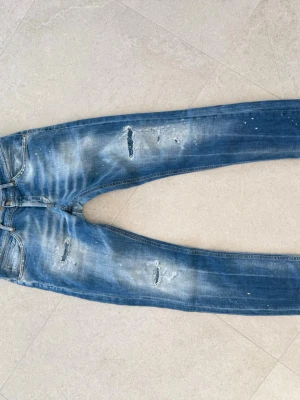 Dondup jeans - Säljer ett par blå jeans från Dondup. Jeansen har ett reparerat hål mellan benen annars i fint skick.