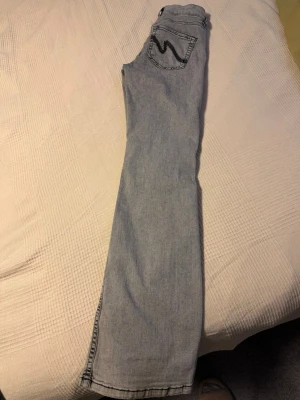 Bootcut jeans från Nelly, ljusblå - Gråa bootcut jeans från Nelly i modell low waist. Klassisk femficksdesign med snygg kontrastsöm på bakfickan. Jeansen är i mjukt denimtyg och har en avslappnad bootcut-passform som ger en schysst siluett.