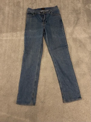 Lee jeans - Säljer ett par klassiska blå jeans från Lee i modellen WEST. Jeansen har rak passform. Lee lapp bak i midjan. Hör av er vid frågor eller funderingar📩