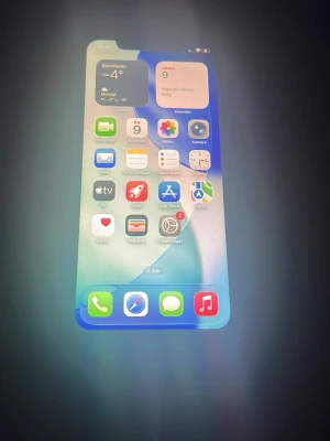 iPhone 11 64GB - Säljer en vit iPhone 11 med 64GB lagring. Telefonen är i gott skick med synliga tecken på normalt bruk. Batterihälsan är 73% och ett servicemeddelande visas, vilket innebär att batteribyte rekommenderas. Alla funktioner fungerar och iOS 16.1 är installerat.