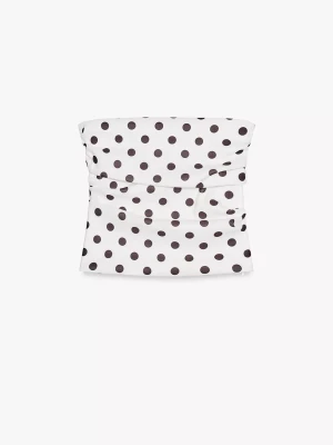 Vit prickig bandeau tubtopp - Säljer en vit bandeau tubtopp med svarta prickar. Toppen är axelbandslös och har en slät, figurnära passform. Materialet känns mjukt och har en lätt glans, perfekt för sommarens varma dagar. Prickmönstret ger en lekfull och trendig vibe.