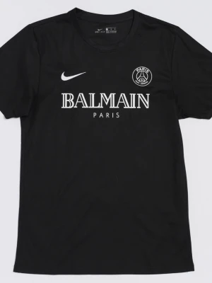 Svart PSG x Balmain t-shirt Nike - Svart t-shirt med Paris Saint-Germain-logga och stor vit Balmain Paris-tryck på bröstet. Klassisk Nike Swoosh på ena sidan. T-shirten har rund hals och är kortärmad, tillverkad i ett lätt och sportigt material som andas.