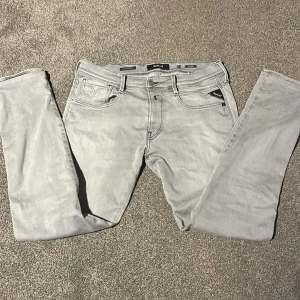 Replay Anbass ljusgrå jeans, stl 32 - Snygga ljusgrå Replay Anbass jeans i klassisk femficksmodell. Jeansen har raka ben, diskreta sömmar och detaljer som Replay-logga på fickan och bak. Tillverkade i mjukt denimtyg som sitter skönt hela dagen.