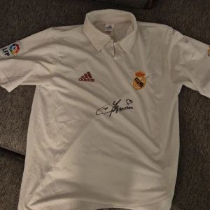 Real madrid orginaltröja 2002-03 Signerad av Lilian Thuram - Jag säljer en orginaltröja från real madrid. Tröjan är från säsongen 2000-03. Den är signerad ev fotbollsspelaren Lilian thuram.