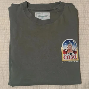  Casablanca  - Casablanca t-shirt i grått med färgglatt tryck av byggnad och texten 'casa' på bröstet och ryggen. Rund hals och klassisk passform. Möts upp i Gbg billigare! Först till kvarn