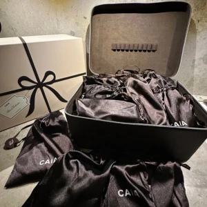 CAIA Adventskalender med smink - Pris kan diskuteras. Exklusiv adventskalender från CAIA med flera sminkprodukter i svarta satinpåsar, levereras i en lyxig beige presentbox och brun sminkväska. Perfekt för dig som vill testa olika smink från CAIA, allt snyggt förpackat och redo att överraska.