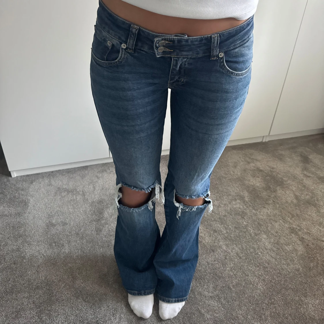 Blå bootcut jeans med slitna knän