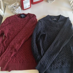 Vinröd och marinblå kabelstickad tröja - Två snygga kabelstickade tröjor från Bondelid, en i vinrött och en i marinblått. Båda har rund hals, ribbade muddar och långärmad passform. Perfekt för dig som gillar klassisk stil med twist. Materialet är mjuk bomull som känns skönt mot huden. ”Priset ej hugget i sten!”