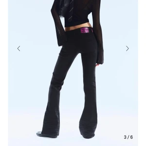 Svarta bootcut jeans Cheap Monday - Svarta jeans från Cheap Monday med bootcut-snitt och klassisk femficksdesign. Byxorna har en lila etikett med tryck bak i midjan och är tillverkade i stretchig bomull. Passformen är normal och midjan är midwaist. Perfekt för dig som gillar retrovibbar och snygg siluett. För små på mig därav säljer jag de.