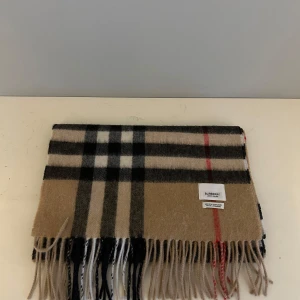 Burberry scarf/halsduk - Burberry halsduk i vanlig storlek, mycket fint skick, endast scarfen medföljer, priset kan diskuteras vid snabb affär så kom gärna med bud!