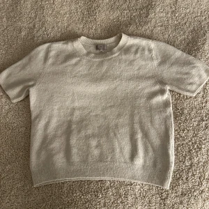 Beige/Vit stickad tröja från H&M - Säljer denna jättefina stickade T-shirten då jag inte använder den. Jättefint skick dock lite nopprig. Storlek M men passar dig som har S/XS också💕 Pris kan diskuteras 