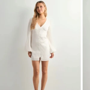 Vit kort omlottklänning med v-ringning - Klänning från Nelly jag hade tänkt ha till studenten. Var för stor på mig och därav säljer jag den. Klänningen är oanvänd och har lappen kvar💞