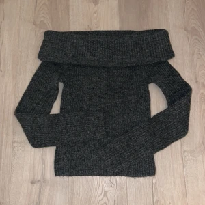 Mörkgrå offshoulder stickad tröja H&M - Säljer en mörkgrå stickad tröja från H&M i storlek XS. Tröjan har en bred offshoulder-krage och är ribbstickad med långa ärmar. Perfekt för dig som gillar en chill och snygg look med lite extra edge.