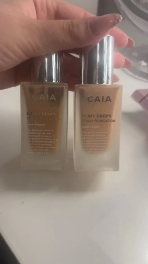 CAIA Dewy Drops Serum Foundation 20C & 30C - Två flaskor CAIA Dewy Drops Serum Foundation, nyanserna 20C och 30C.  Ger en dewy finish och innehåller vitamin E och glycerin för återfuktning. Perfekt för dig som vill ha en naturlig glow och lätt täckning. Helt oanvända. Styck pris 120kr