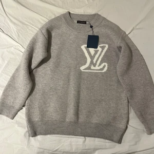 Grå stickad Louis Vuitton tröja S - Grå stickad tröja från Louis Vuitton med vitt LV-logo.                                                                                - skick: 10/10, helt ny - Storlek: S  DM för fler bilder, detaljer och frågor!🫱🏾‍🫲🏽 