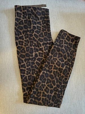 Leopardmönstrade byxor från H&M - Snygga byxor från H&M i storlek 38 med leopardmönster i bruna och svarta toner. Modellen har en elastisk midja och är tillverkad i ett mjukt bomullsmaterial. 