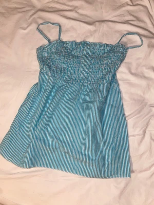 Randig atmosphere babydoll topp - Detta linne är så gulligt och har så fin modell. Resoret över bröstet gör toppen fint utsvännd, som en babydoll topp. De blåa och vita ränderna är också så söta! #sommar #2000s #babydoll topp #knappar #stockholm