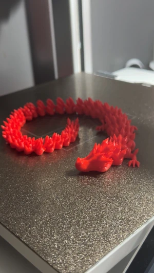 3D-printad 36cm LÅNG Flexibel drake - Unik leksak i form av en drake, 3D-printad i skimrande röd plast. Draken har detaljerade fjäll och ett coolt drakhuvud som ger en fantasy-vibe. Perfekt för dig som vill sticka ut med coolare leksaker/dekorationer som verkligen syns. För andra färger eller former är ni välkommen att meddela mig! 