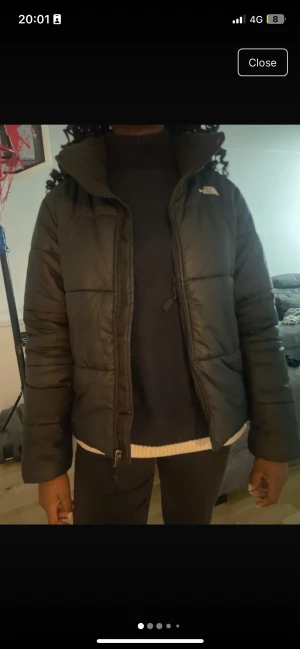 Svart pufferjacka från The North Face - Säljer en svart pufferjacka från The North Face i storlek L. Jackan har hög krage, långärmade ärmar och dragkedja framtill. Den är tillverkad i syntetmaterial och har en clean, klassisk look med logga på bröstet och ryggen. Perfekt för kalla dagar. Köpte den för 2800kr. Pris kan diskuteras 
