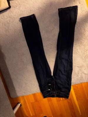 Mörkblå jeansbyxor från MAN - Snygga mörkblå jeansbyxor från MAN med klassisk femficksdesign och kontrastsömmar. Modellen har rak passform och normal midja, tillverkade i slitstarkt denimtyg. Perfekt för dig som gillar stilrena och tidlösa jeans.