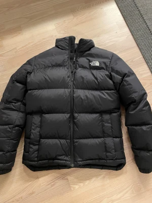 Svart pufferjacka från The North Face - En pufferjacka från north face som kommer hålla värmen nu till vintern. Sitter bra och passar dom som är runt 170-180. Nypris 3000kr och mitt pris 1499kr. Hör av er om ni har någon fundering!