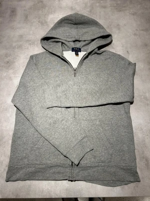 Hoodie med dragkedja från Ralph Lauren  - Vi säljer nu denna grå zip-hoodie från Ralph Lauren! | Storleken är i barnstorlek XL och sitter alltså som S. | Vi tar emot rimliga prisförslag! | Finns möjlighet att köpa bundle i vår profil för ett billigare pris! | Kontakta vid minsta fundering! 