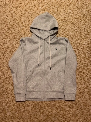 Grå Ralph lauren hoodie - Säljer min gråa Ralph lauren zip hoodie. Den är i mycket bra skick och bara testat den. Storlek är M. Den är väldigt stilren och passar till vad som helst. Vid fler frågor kom privat