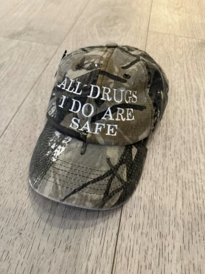 Keps i camo med text  - Helt ny keps med fet text i camouflage 