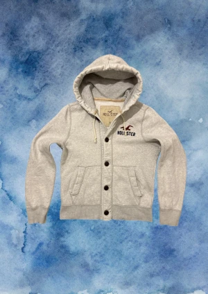 Vintage Hollister Cardigan Med Knappar - Säljer denna otroliga sällsynta och feta Hollister cardigan med knappar | Mycket bra skick, förutom en liten slitning på slutet av högra ärmen | Längd ≈ 64cm, Bredd armhåla - armhåla 54 cm | Modell 175, 68 kg