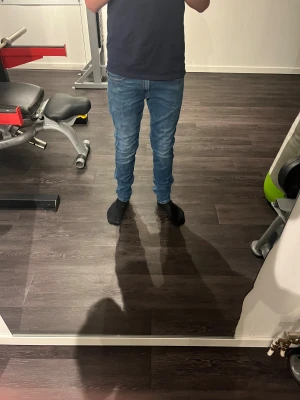 Replay blå skinny jeans herr - Snygga blå jeans från Replay med skinny passform och klassisk femficksdesign. Jeansen har ljusa slitningar och detaljerade sömmar på bakfickorna. Materialet är stretchigt jeans och midjan är normal. Perfekt för dig som gillar en smal siluett.