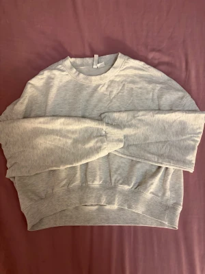 Ljusgrå sweatshirt från H&M Basic - En enkel och stilren ljusgrå sweatshirt från H&M Basic. Tröjan har rund hals, ribbade muddar vid ärmslut och nederkant samt långärmad passform. Perfekt för chill dagar och enkel att matcha med jeans eller mjukisbyxor. Ser snyggare ut på!!🩷