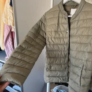 Grön quiltad pufferjacka från H&M - Säljer en grön quiltad pufferjacka från H&M. 