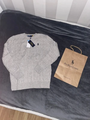 Stickad grå ralph lauren tröja - Hej säljer en oanvänd stickad grå ralph lauren i storlek M😊. Nypris 1200kr men mitt pris 900kr. Skriv gärna om ni har funderingar! 👍