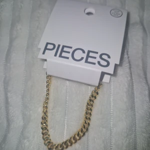 Armband - Snyggt armband från Pieces med chunky kedjedesign, pläterat med 18K roséguld. Armbandet har justerbar längd och en glansig finish som ger en cool och trendig vibe. Perfekt för dig som gillar statement-smycken och vill addera lite extra bling till din stil.