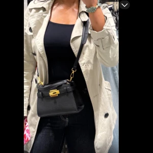 Beige trenchcoat med svarta knappar - Stilren beige trenchcoat från H&M med klassisk dubbelknäppning, supersnygg nu till höst och sitter som en smäck. Tvättad och stryks innan leverans☺️