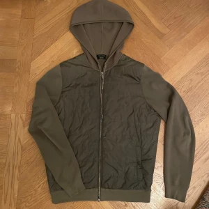 Massimo Dutti cardigan - Säljer min skit snygga Massimo dutti cardigan! Huvan, ärmarna och baksidan är stickad i materialet bomull och framsidan är av ”väst material”. Jackan är i bra skick men en liten fläck på ryggen.