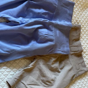 Sömlösa träningsshorts - Två par sömlösa shorts från SOC, ett par i ljusblått/lila och ett par i beige. Båda har bred ribbad midja med logga, tight passform och stretchigt material som passar perfekt till träning. Supersköna och snygga för gymmet! Båda för 50kr! Eller en för 30💗