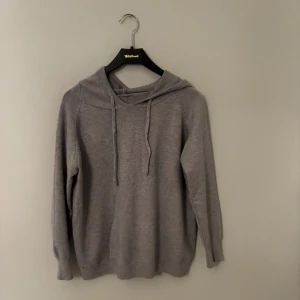 Grå merino hoodie  - Säljer en grå meriono hoodie med huva och snörning framtill. Tröjan är ny utan prislapp så därför inga defekter eller konstigheter. Passar XS-S