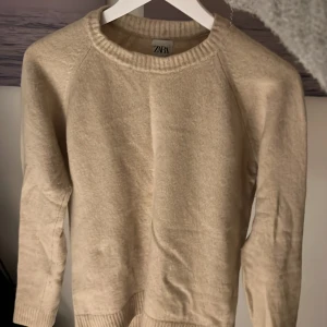 Beige stickad tröja från Zara - Mysig beige stickad tröja från Zara med rund halsringning. Bra skick lite nopprig men enkelt att ta bort. Storlek M men passar också S. Nypris runt 500-600kr mitt pris 200kr. Kontakta mig om du har frågor 