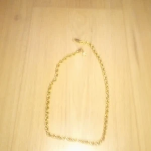 Guldfärgat tvinnat halsband - Snyggt guldfärgat halsband med tvinnad kedja som ger en cool och trendig look. Perfekt accessoar för att lyfta din outfit och sticka ut lite extra. Lätt att matcha med andra smycken och passar både tjejer och killar.