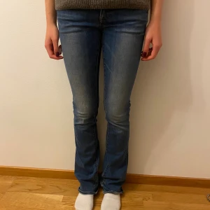 Blå bootcut jeans från G-Star RAW -  Snygga blå jeans från G-Star RAW med bootcut passform och klassisk femficksdesign. Jeansen har en medelhög midja och är tillverkade i mjukt denimtyg med lätt slitning på låren och bakfickor med broderad detalj. Strl 24/34 skulle säga att dom är lite stora i storleken och passar bra i längden jag är 170. 