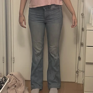 Ljusblå bootcut jeans - Säljer ett par ljusblå jeans med bootcut-modell och klassisk femficksdesign. Jeansen har hög midja och är tillverkade i ett mjukt denimtyg som ger en skön passform. Perfekta för dig som gillar en retroinspirerad look med lite utsvängda ben.