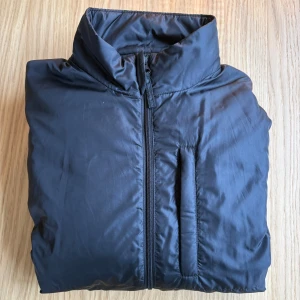 Mörkblå jacka från Aspesi  - Mörkblå pufferjacka från Aspesi med Thermore-isolering. Jackan har hög krage, dragkedja framtill och tre fickor. . Perfekt för höst/vår eller under andra jackor. Storleken är i S men Aspesis storlekar är mindre än andras. Passar nog bäst för någon som är mellan  XS och S. Jackan är oanvänd. 