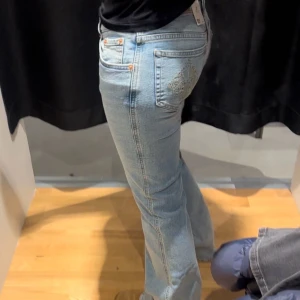Ljusblå bootcut jeans med broderi - Säljer ett par ljusblå lågmidjade bootcut jeans med snyggt broderat mönster på bakfickan. Kommer inte till användning längre, bra skick