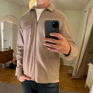 Beige Overshirt med dragkedja Topman - Säljer denna sjukt snygga Overshirten från Topman⭐️ Färgen är beige och storleken är M✅ Den har inga defekter och skicket är utomordentligt🙌🤝 Sjukt najs passform och passar perfekt till hösten🍁🙌 Tveka inte på att höra av er dig vid minsta fråga eller fundering😊